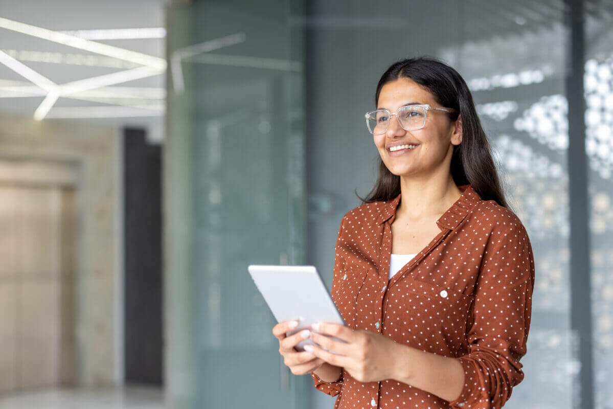 Young economist using a tablet. Woman in office, researching economics data for financial analysis. Business student.