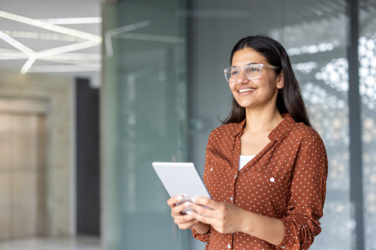 Young economist using a tablet. Woman in office, researching economics data for financial analysis. Business student.