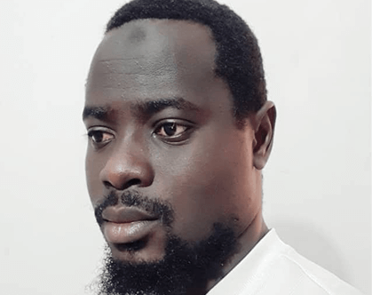 Chemistry expert: Portrait of thoughtful Black man with beard, looking off to the side in a white shirt.