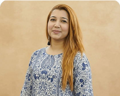 Chemistry expert: Portrait of a smiling woman with auburn hair wearing a patterned blouse.