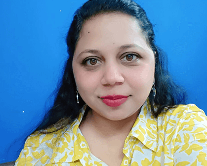 Chemistry teacher portrait with yellow floral shirt against blue background. Science education professional.