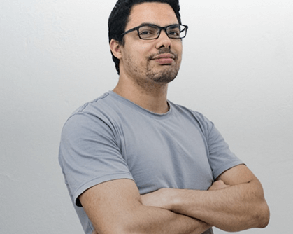 Physics expert with glasses, arms crossed. Confident scientist for physics education resources; science professional portrait.